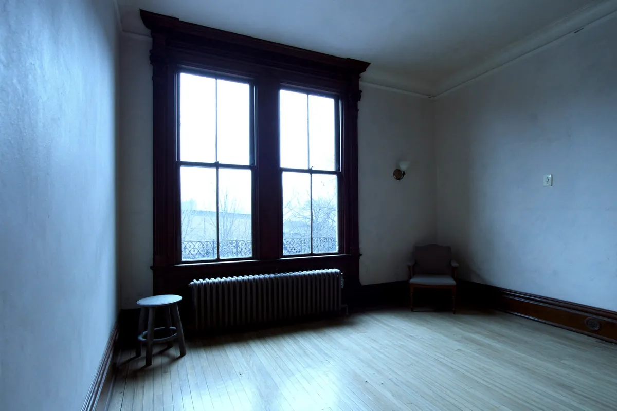 Wood double-hung window and cast iron radiator in a room in Chicago, Illinois