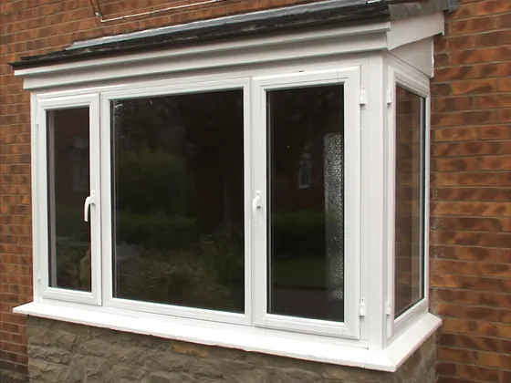 Bay window of three units projecting from a brick wall
